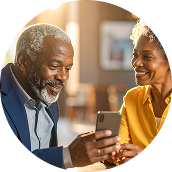 Casal afro-americano idoso sorrindo enquanto olha para um smartphone.