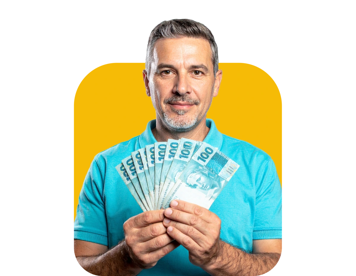 Homem sorrindo segurando notas de 100 Reais, dinheiro brasileiro.