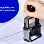 Documento sobre uma mesa clara sendo carimbado por um carimbo automático metálico segurado por uma mão. À esquerda, um círculo azul com o texto “Escritura pública na Cessão de Precatórios”. O layout utiliza elementos gráficos azuis nos cantos e remete à formalização e validação de documentos jurídicos.